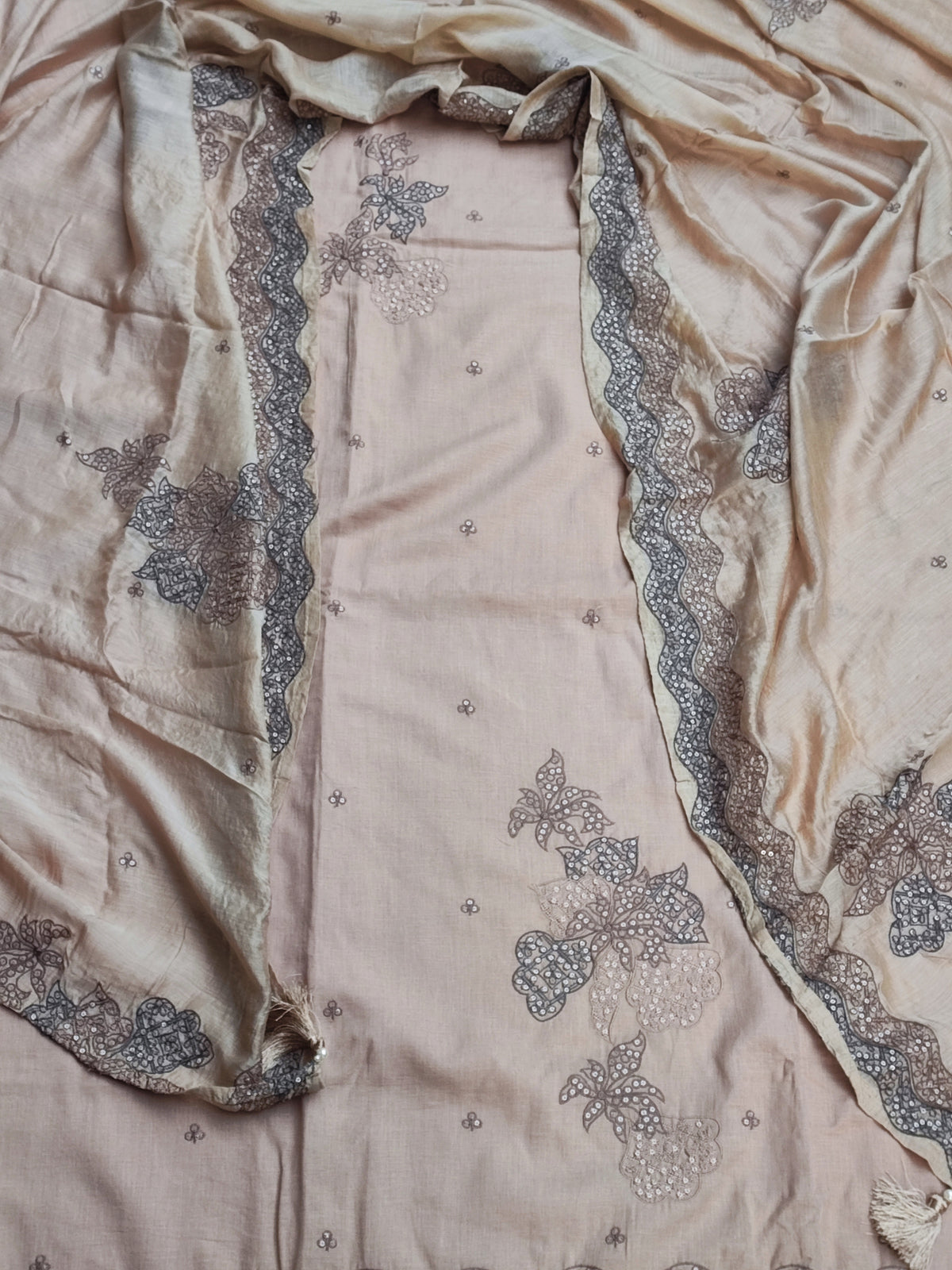 Handmade tassel hanging on corner of beige tabby silk dupatta