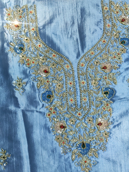 Close-up of hand embroidery with stone, pearl, sippi and katdana work on blue silk
