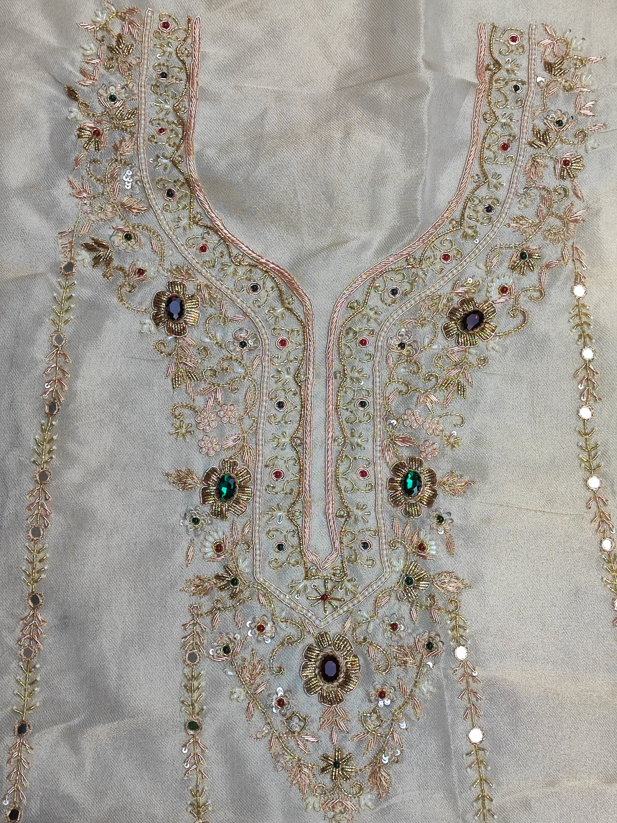 Close-up of hand embroidery with coloured stones, pearl, sippi and katdana on ivory tissue