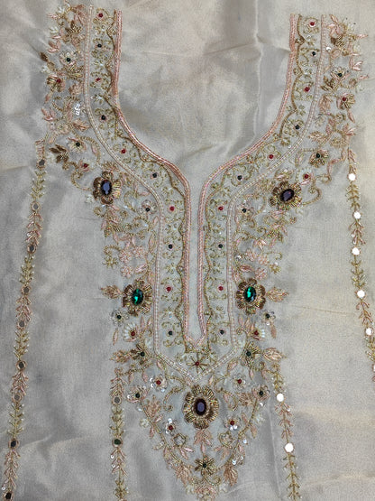Close-up of hand embroidery with coloured stones, pearl, sippi and katdana on ivory tissue