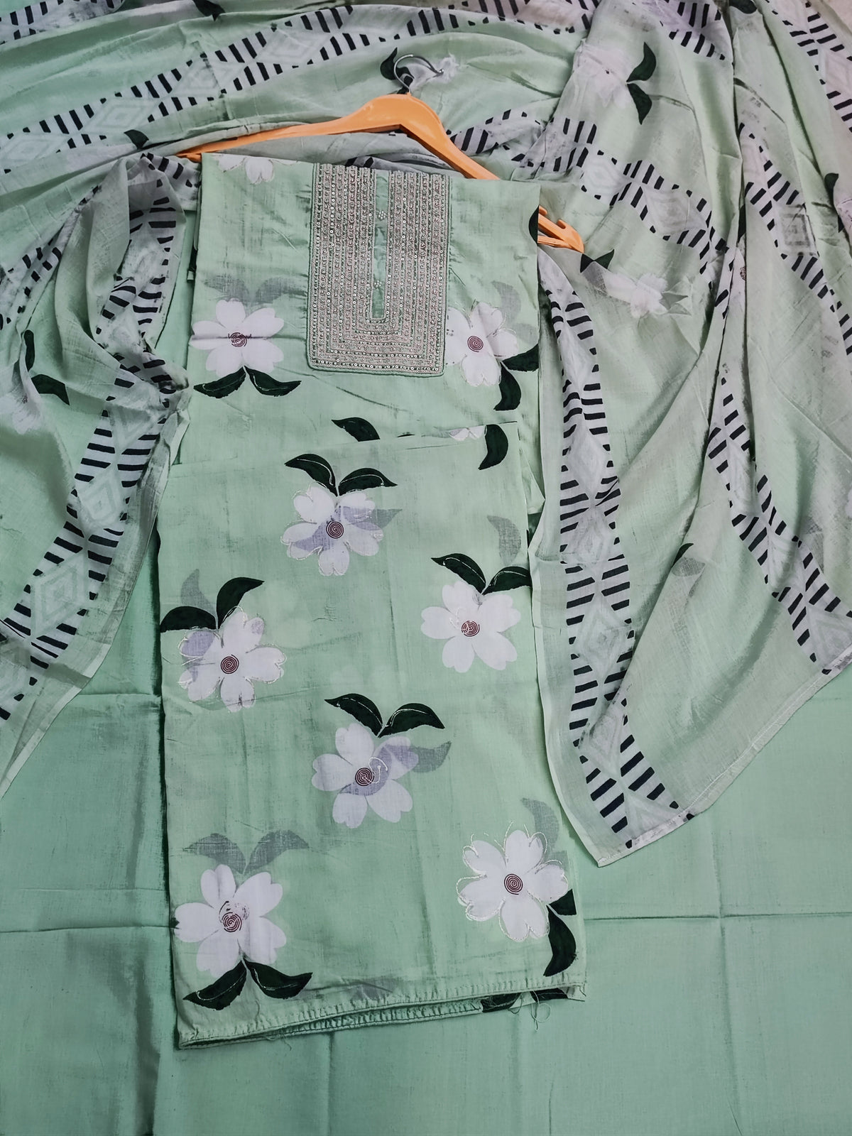 Close-up of thread work placket panel on pastel green cotton shirt