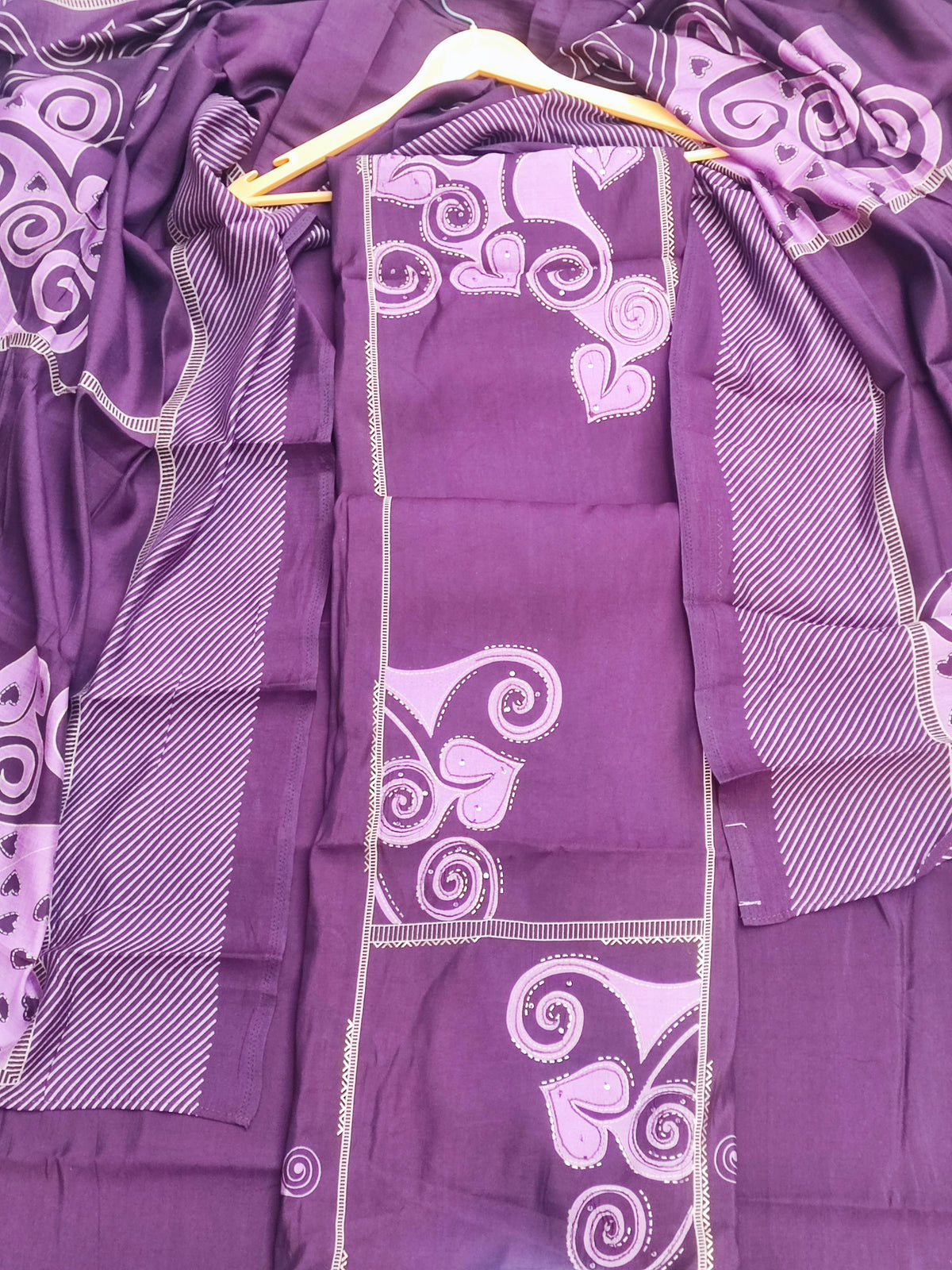 Close-up of lilac swirl and leaf print on deep plum muslin