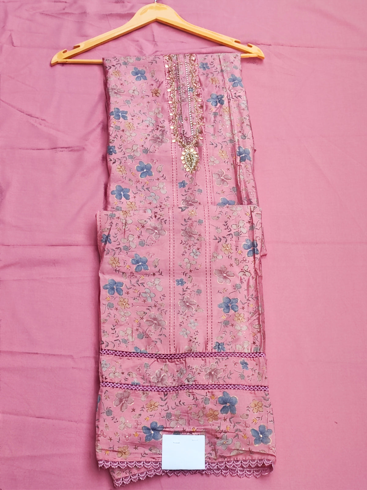 Close-up of gold beadwork, sequin and pearl handwork on pink muslin neckline