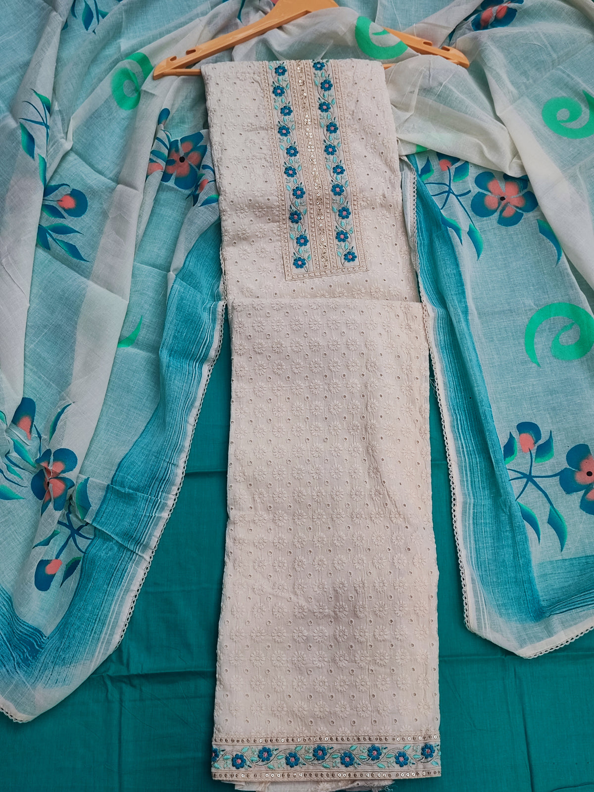 Close-up of chikankari work and blue floral placket panel on cream cotton shirt