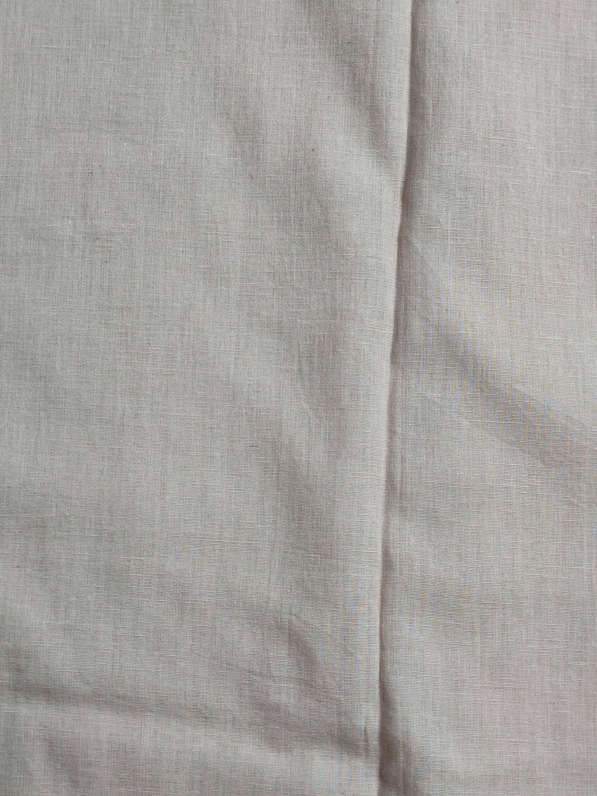 Detail of sequin and chain-stitch scalloped panel on beige linen shirt
