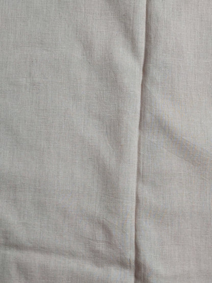 Detail of sequin and chain-stitch scalloped panel on beige linen shirt
