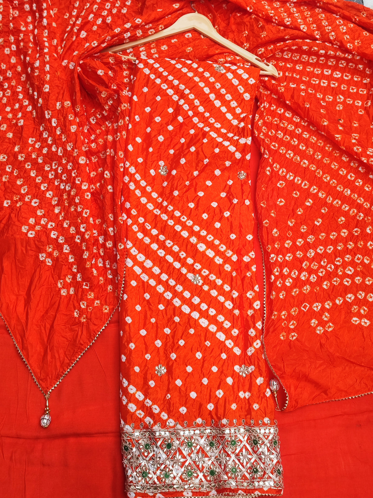 Close-up of gota patti and stone work border on orange bandhani shirt hem